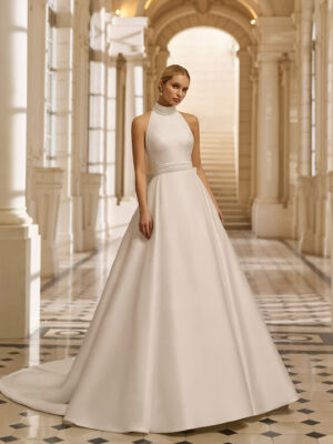 Vestido de novia Aire Barcelona 2027 de mikado con escote halter, cintura marcada y falda línea A de estilo minimalista y elegante.