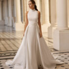 Vestido de novia Bahamas de Aire Barcelona 2027 con cuello halter, corte evasé, sobrefalda desmontable y espalda descubierta.