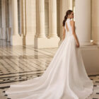 Vestido de novia Bahamas de Aire Barcelona 2027 con cuello halter, corte evasé, sobrefalda desmontable y espalda descubierta.