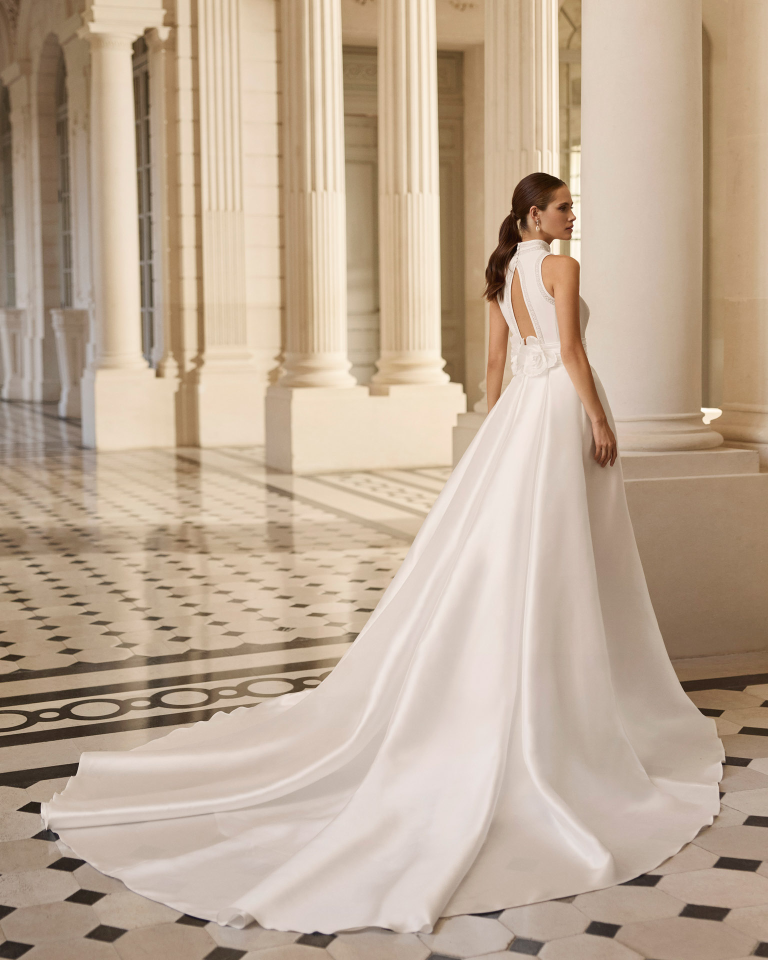 Vestido de novia Bahamas de Aire Barcelona 2027 con cuello halter, corte evasé, sobrefalda desmontable y espalda descubierta.