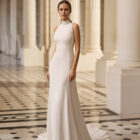 Vestido de novia Bahamas de Aire Barcelona 2027 con cuello halter, corte evasé, sobrefalda desmontable y espalda descubierta.