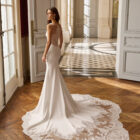Vestido de novia Balma de Aire Barcelona 2027 de corte sirena con escote cuadrado, espalda transparente de encaje y cola con aplicaciones.