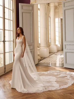 Vestido de novia Balma de Aire Barcelona 2027 de corte sirena con escote cuadrado, espalda transparente de encaje y cola con aplicaciones.