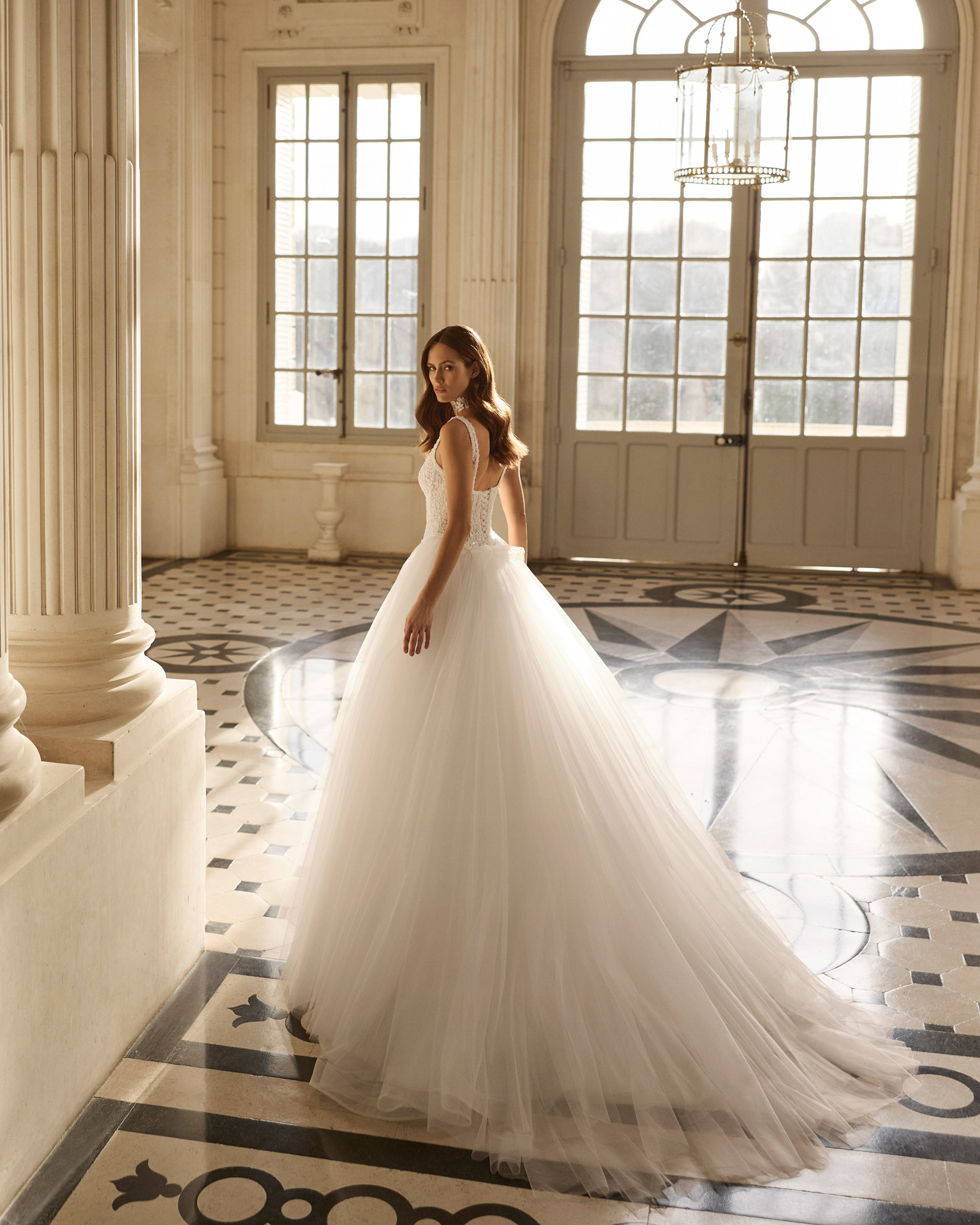 Vestido de novia Betia de Aire Barcelona 2027 de corte princesa con corpiño de encaje floral, escote cuadrado, falda de tul de gran volumen y gargantilla de encaje.