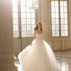 Vestido de novia Betia de Aire Barcelona 2027 de corte princesa con corpiño de encaje floral, escote cuadrado, falda de tul de gran volumen y gargantilla de encaje.