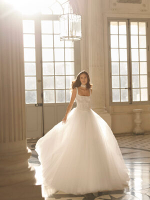 Vestido de novia Betia de Aire Barcelona 2027 de corte princesa con corpiño de encaje floral, escote cuadrado, falda de tul de gran volumen y gargantilla de encaje.