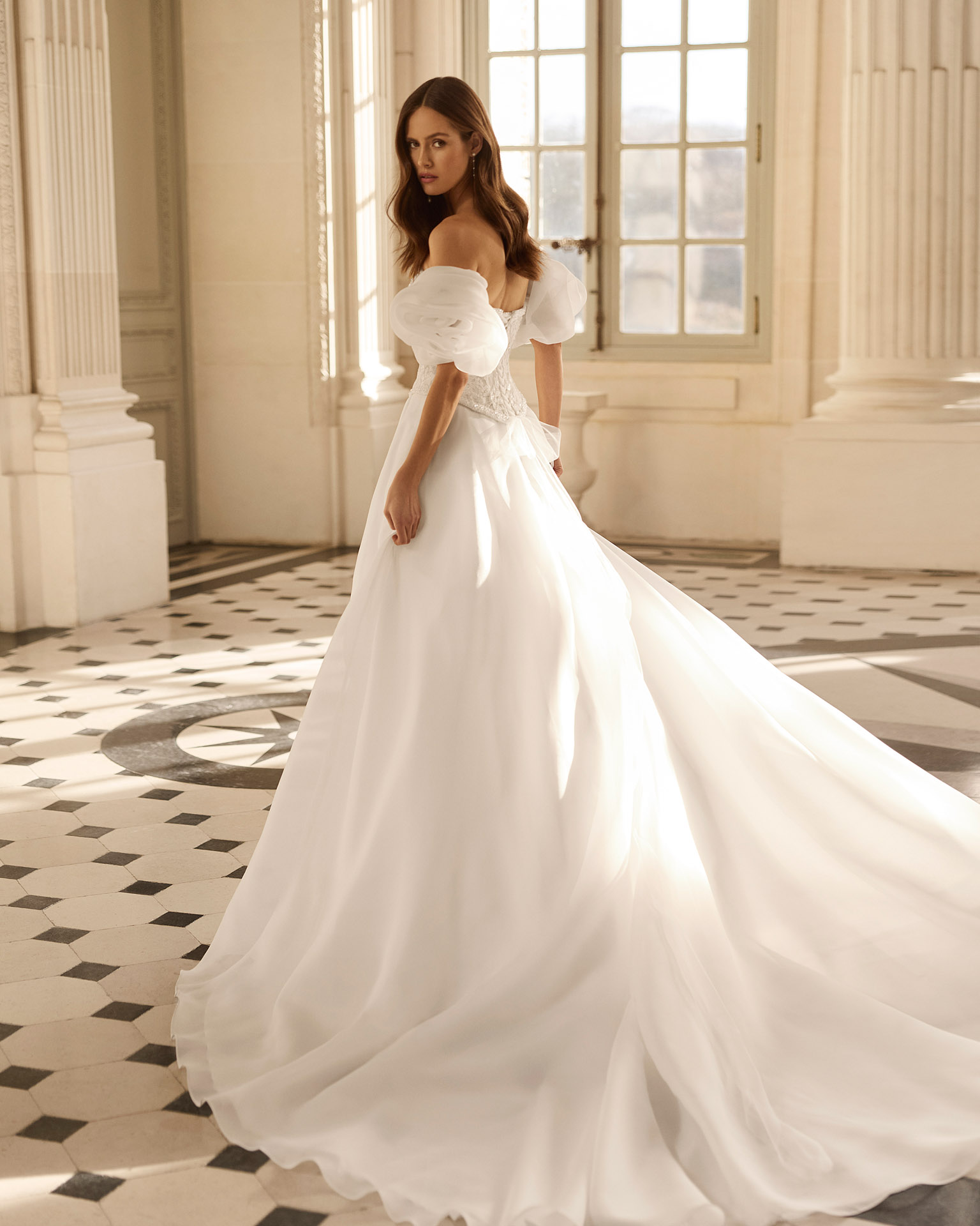 Vestido de novia Beyda de Aire Barcelona 2027 con escote barco, cuerpo corsé de encaje, mangas abullonadas desmontables y falda princesa con abertura.