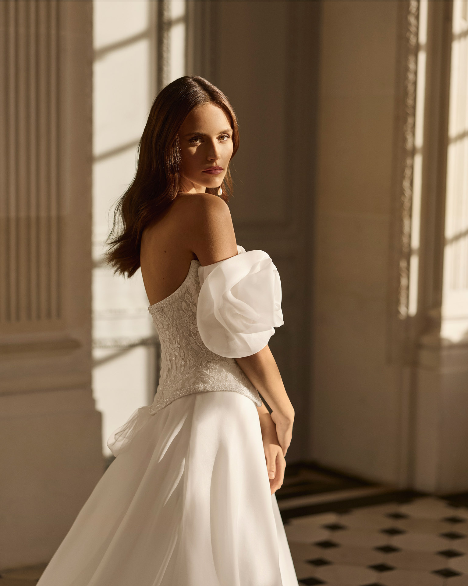 Vestido de novia Beyda de Aire Barcelona 2027 con escote barco, cuerpo corsé de encaje, mangas abullonadas desmontables y falda princesa con abertura.