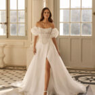 Vestido de novia Beyda de Aire Barcelona 2027 con escote barco, cuerpo corsé de encaje, mangas abullonadas desmontables y falda princesa con abertura.