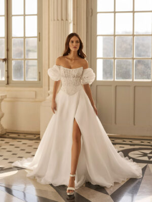 Vestido de novia Beyda de Aire Barcelona 2027 con escote barco, cuerpo corsé de encaje, mangas abullonadas desmontables y falda princesa con abertura.