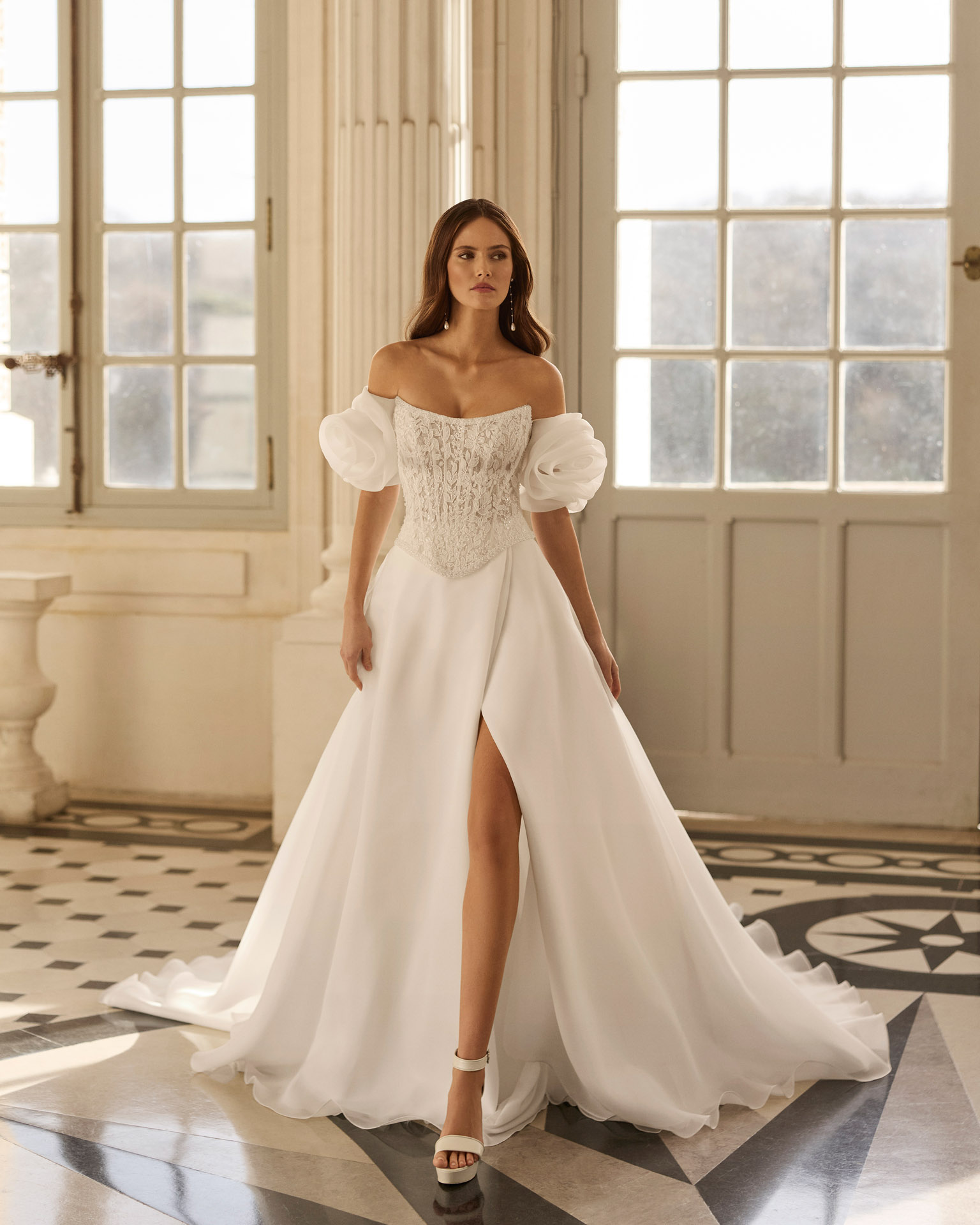 beyda-vestido-novia-princesa-corset-escote-barco-aire-barcelona-2027.frente Vestido de novia Beyda de Aire Barcelona 2027 con escote barco, cuerpo corsé de encaje, mangas abullonadas desmontables y falda princesa con abertura.