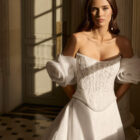 Vestido de novia Beyda de Aire Barcelona 2027 con escote barco, cuerpo corsé de encaje, mangas abullonadas desmontables y falda princesa con abertura.