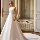 Vestido de novia Blayra de Aire Barcelona 2027 confeccionado en mikado con escote barco, espalda transparente bordada y gran lazo en la cintura.