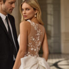 Vestido de novia Blayra de Aire Barcelona 2027 confeccionado en mikado con escote barco, espalda transparente bordada y gran lazo en la cintura.