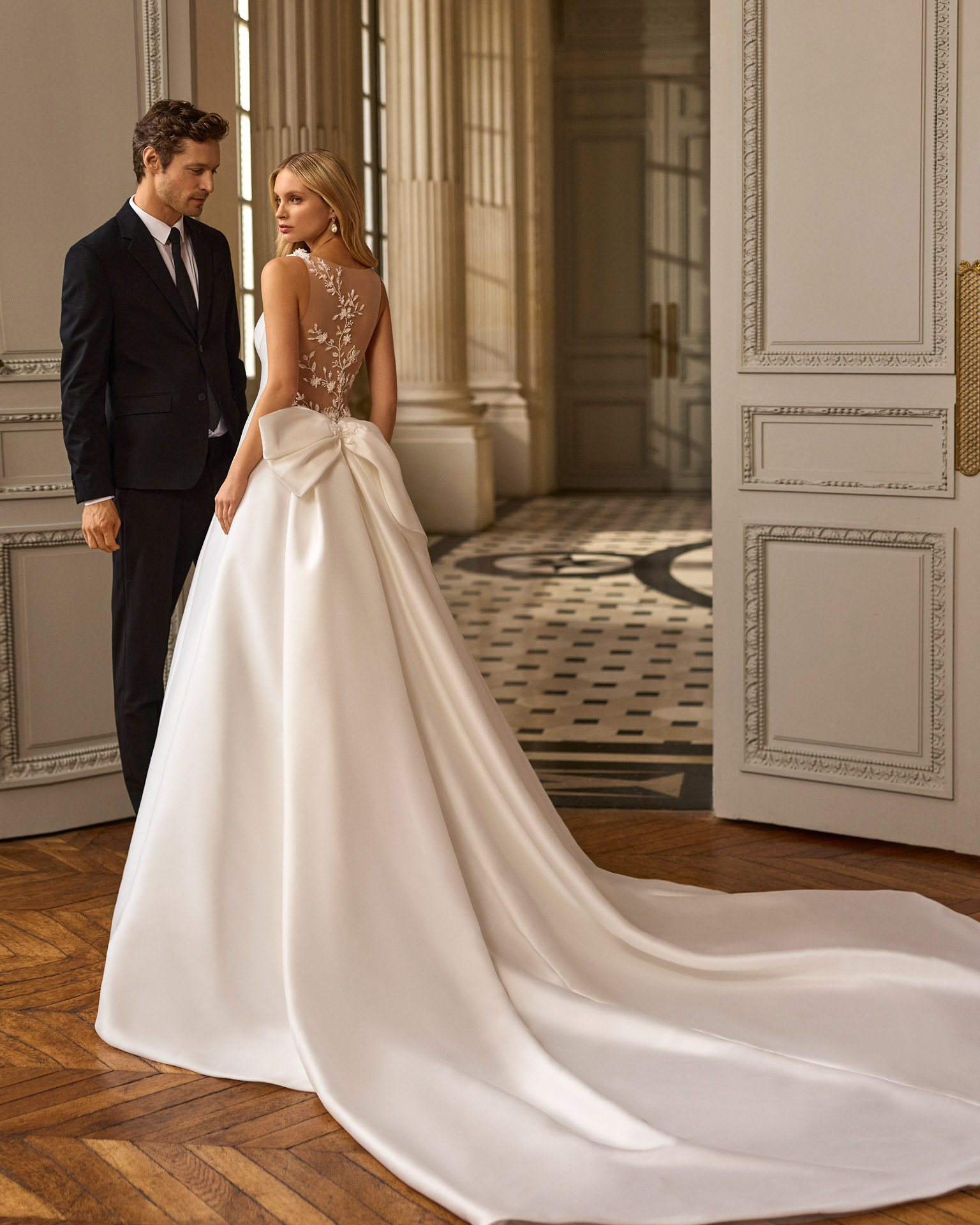Vestido de novia Blayra de Aire Barcelona 2027 confeccionado en mikado con escote barco, espalda transparente bordada y gran lazo en la cintura.