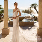 Vestido de novia Fado de Luna Novias 2027 de corte sirena en encaje, escote profundo en V, mangas japonesas de encaje y espalda abierta con delicados tirantes de pedrería.