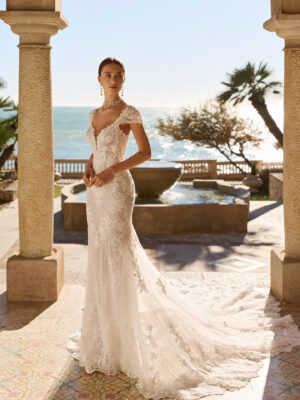 Vestido de novia Fado de Luna Novias 2027 de corte sirena en encaje, escote profundo en V, mangas japonesas de encaje y espalda abierta con delicados tirantes de pedrería.