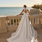 Vestido de novia Fluvia de Luna Novias 2027 de corte princesa, cuello alto y cuerpo de encaje bordado con falda lisa.