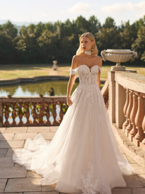 Vestido de novia Fresa de Luna Novias 2027 de corte A con escote barco, mangas caídas de encaje floral, delicado choker de encaje y falda de tul con aplicaciones florales.