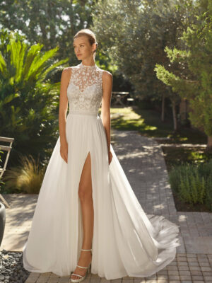 Vestido de novia Malu de Alma Novia 2027 de línea A con cuello halter de encaje, cuerpo bordado, falda de tul con abertura y espalda descubierta.