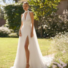 Vestido de novia Malvin de Alma Novia 2027 de corte A en tul plisado, escote halter con cuello envolvente, abertura en la falda y espalda descubierta.