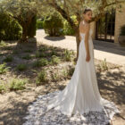 Vestido de novia Marga de Alma Novia 2027 de corte sirena en crepé, escote recto con finos tirantes y espectacular cola de encaje floral.