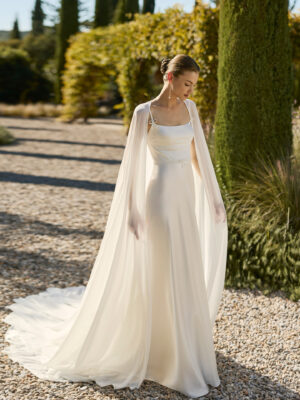 Vestido de novia Marny de Alma Novia 2027 confeccionado en crepé con escote cuadrado, tirantes finos y elegante capa de gasa de estilo minimalista.