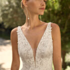 Vestido de novia Milano de Alma Novia 2027 con escote pico, cuerpo de encaje floral, falda de tul con abertura delantera y silueta romántica.