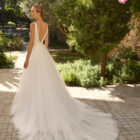 Vestido de novia Milano de Alma Novia 2027 con escote pico, cuerpo de encaje floral, falda de tul con abertura delantera y silueta romántica.