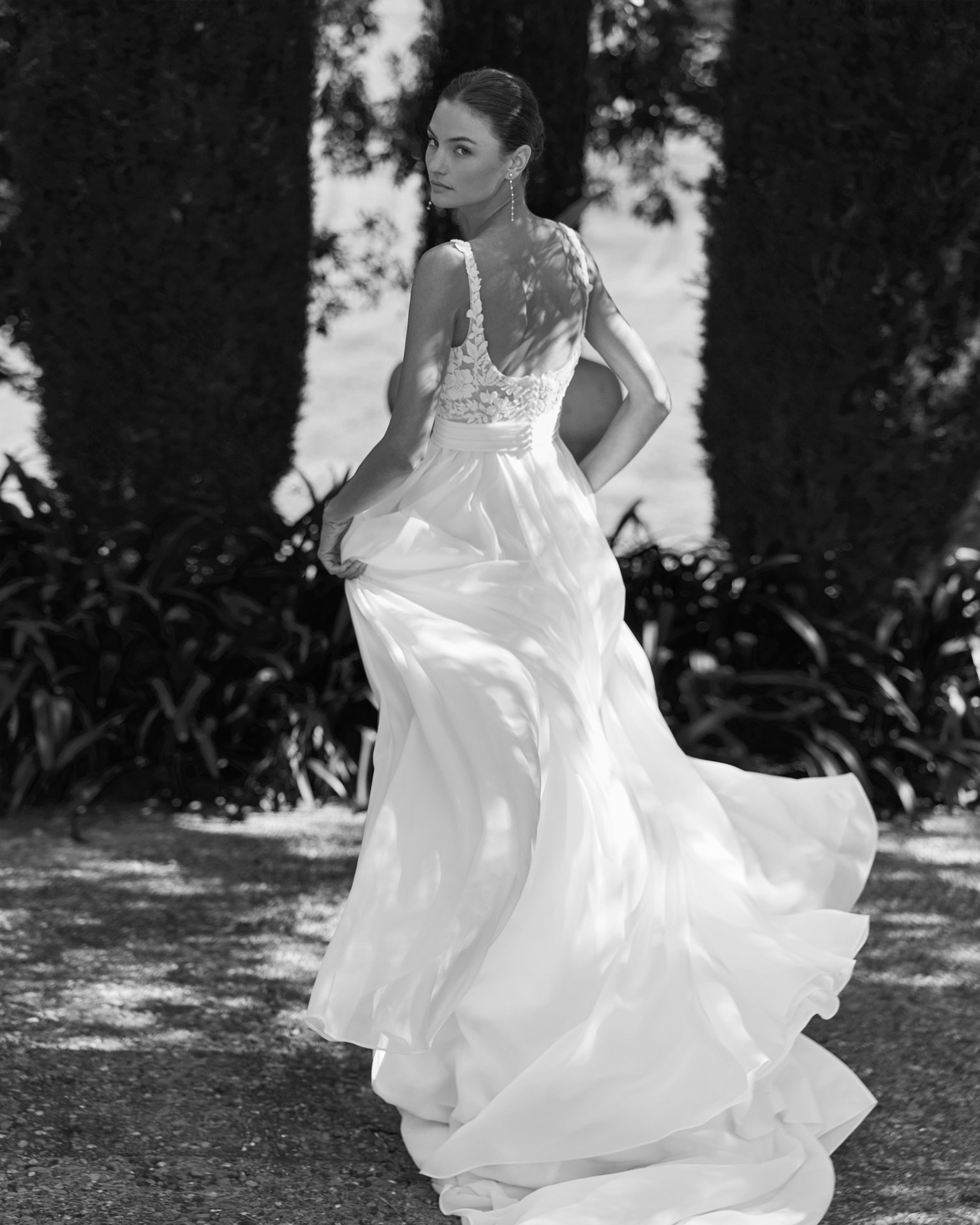 Vestido de novia Moira de Alma Novia 2027 con escote cuadrado, cuerpo de encaje floral, falda de crepé con abertura delantera y estilo romántico.