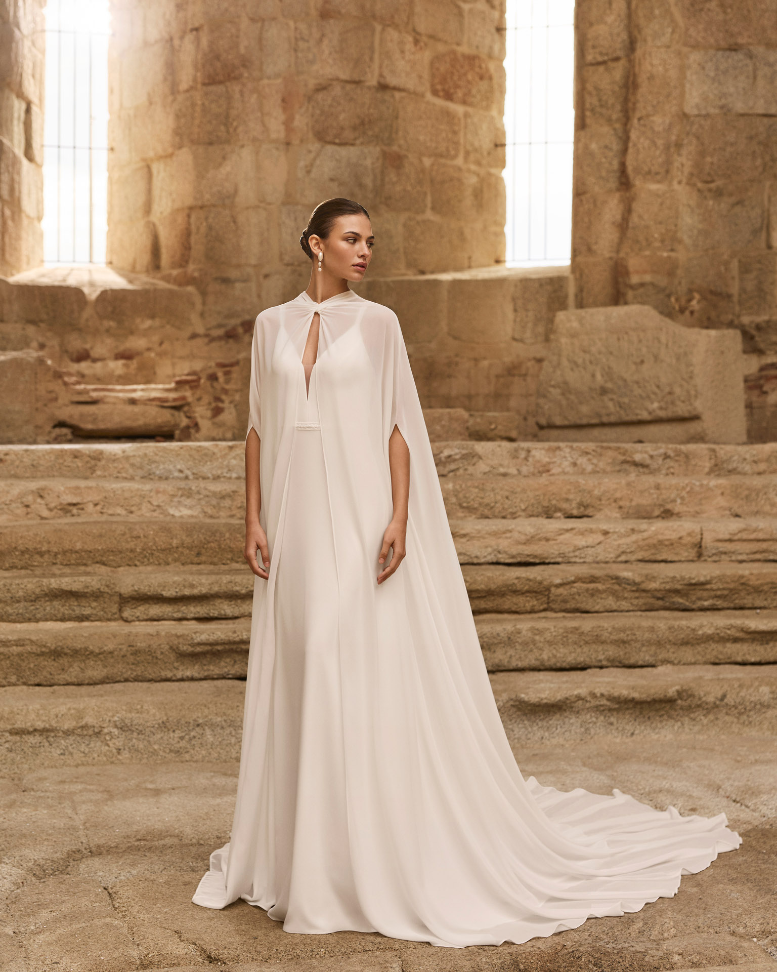 Vestido de novia Palermo de Adriana Alier 2027 con escote en pico, espalda drapeada, tirantes joya y falda fluida de crepé.