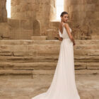 Vestido de novia Palermo de Adriana Alier 2027 con escote en pico, espalda drapeada, tirantes joya y falda fluida de crepé.