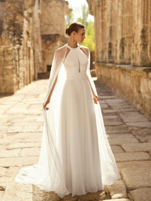 Vestido de novia Palmer de Adriana Alier 2027 con escote halter, falda de gasa plisada, espalda abierta con tirantes joya y estilo romántico.