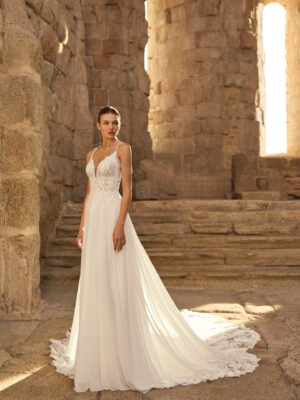 Vestido de novia Paraíso de Adriana Alier 2027 con cuerpo de encaje floral, escote en V, espalda descubierta, falda vaporosa y cola con aplicaciones de encaje.
