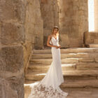 Vestido de novia Paris de Adriana Alier 2027 de corte sirena con escote pico, cuerpo de encaje floral, espalda abierta y cola bordada.