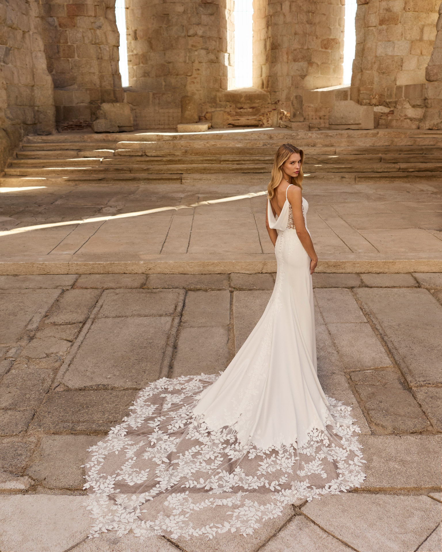Vestido de novia Paris de Adriana Alier 2027 de corte sirena con escote pico, cuerpo de encaje floral, espalda abierta y cola bordada.