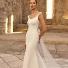 Vestido de novia Parvati de Adriana Alier 2027 de corte sirena en crepé con aplicaciones de encaje floral, escote barco, espalda escotada en V y cola de tul bordada.