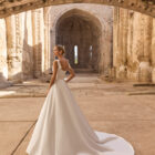 Vestido de novia Planet de Adriana Alier 2027 de línea A con escote cuadrado, cuerpo estructurado con costadillos, lazos en los hombros y falda lisa.