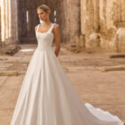 Vestido de novia Planet de Adriana Alier 2027 de línea A con escote cuadrado, cuerpo estructurado con costadillos, lazos en los hombros y falda lisa.