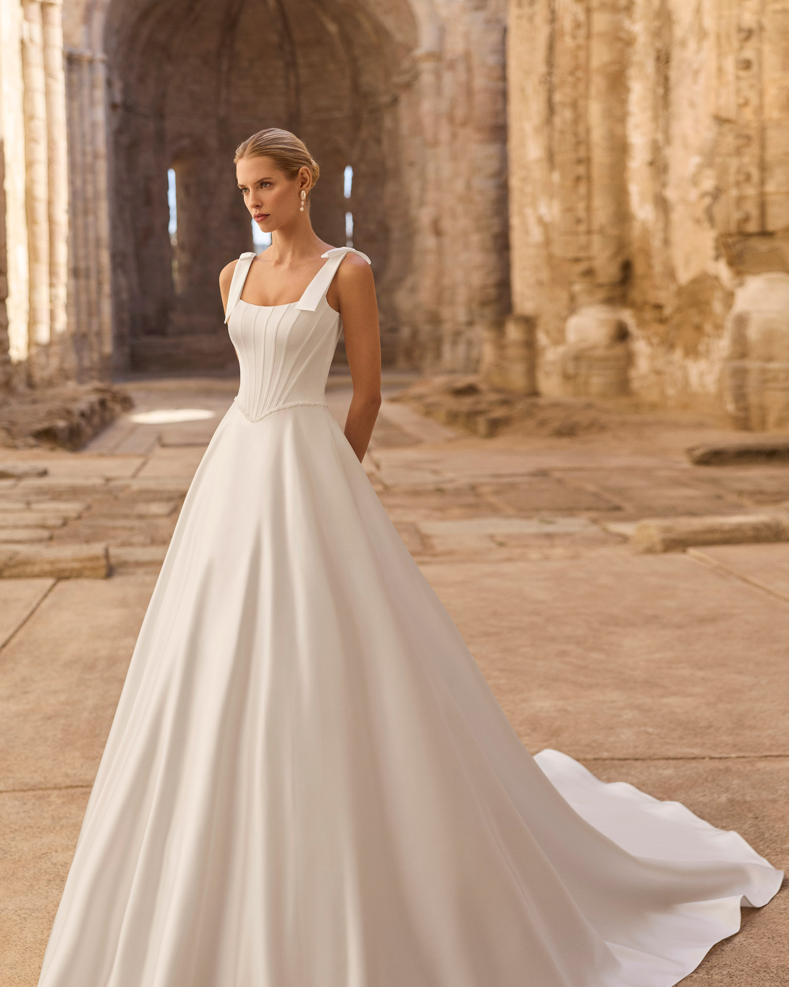 planet-vestido-novia-linea-a-lazos-hombros-adriana-alier-2027.frente Vestido de novia Planet de Adriana Alier 2027 de línea A con escote cuadrado, cuerpo estructurado con costadillos, lazos en los hombros y falda lisa.