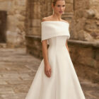 Vestido de novia Pomal de Adriana Alier 2027 de corte A con escote barco, hombros caídos desmontables y diseño minimalista en mikado.