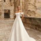 Vestido de novia Pomal de Adriana Alier 2027 de corte A con escote barco, hombros caídos desmontables y diseño minimalista en mikado.