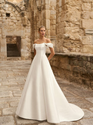 Vestido de novia Pomal de Adriana Alier 2027 de corte A con escote barco, hombros caídos desmontables y diseño minimalista en mikado.