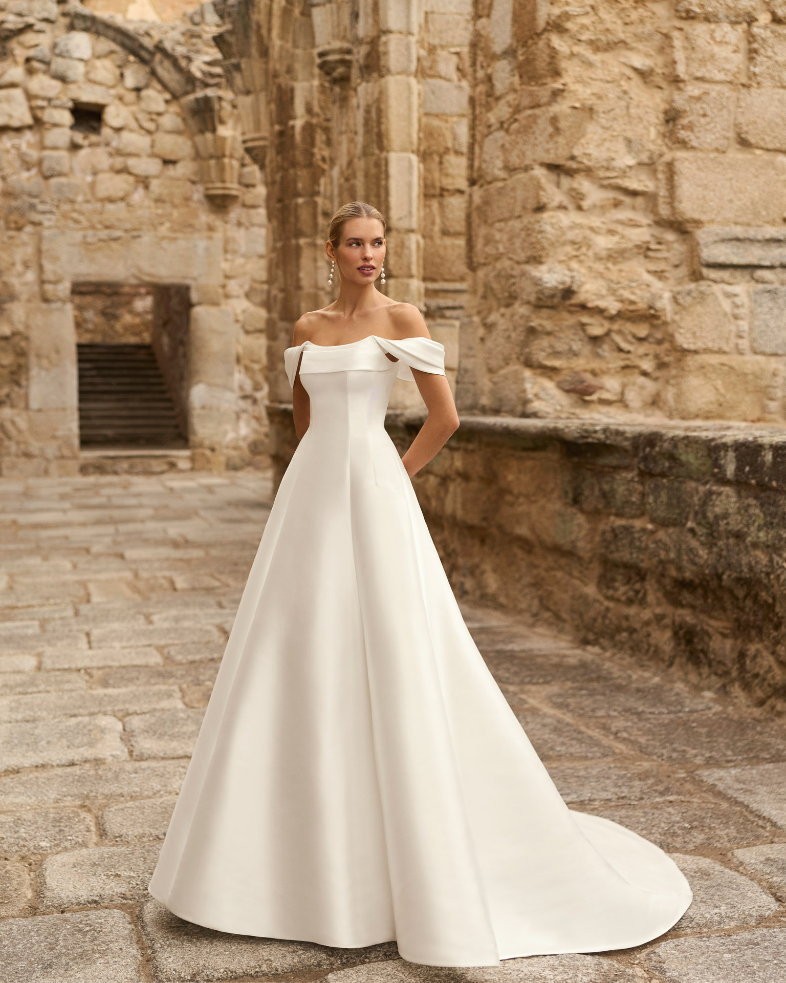 pomal-vestido-novia-minimalista-hombros-caidos-adriana-alier-2027.frente Vestido de novia Pomal de Adriana Alier 2027 de corte A con escote barco, hombros caídos desmontables y diseño minimalista en mikado.