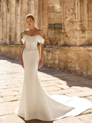 Vestido de novia Pravia de Adriana Alier 2027 de corte sirena en mikado con escote barco, hombros caídos, corsé estructurado y espalda descubierta.