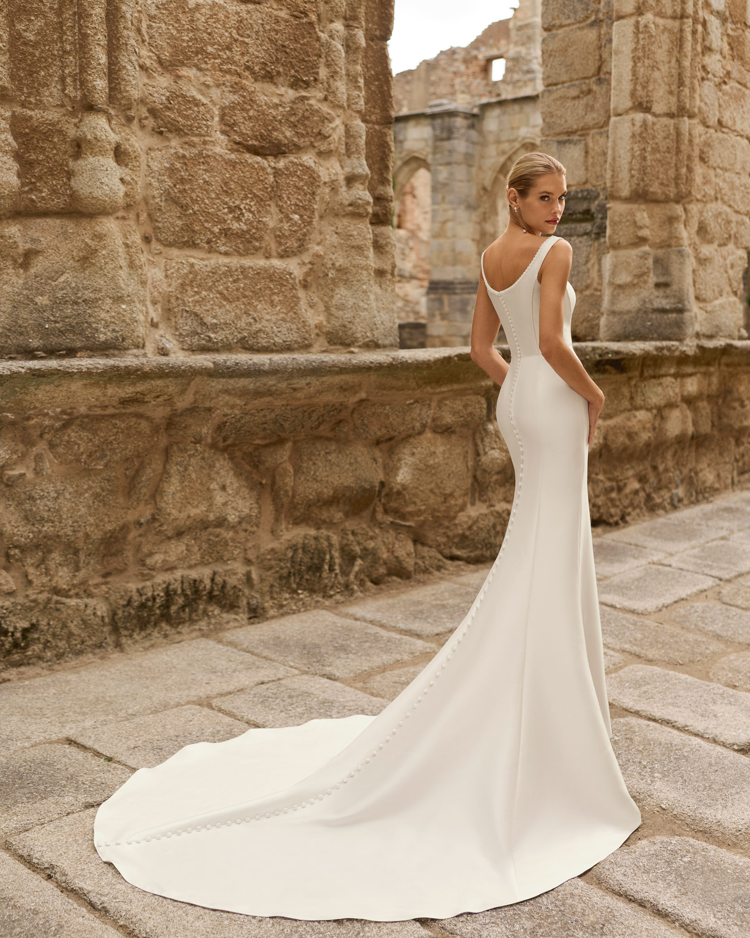 Vestido de novia Prina de Adriana Alier 2027 de línea A con escote barco, cuerpo liso, cintura marcada y falda de gran caída.