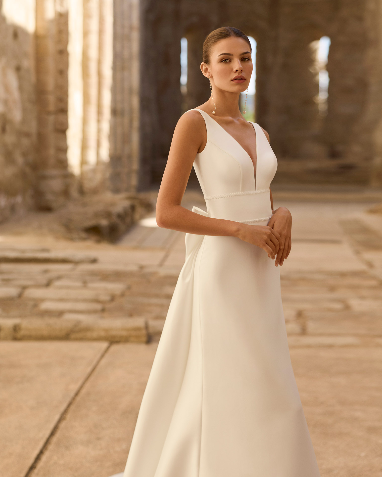 princes-vestido-novia-mangas-gasa-lazo-espalda-adriana-alier-2027.frente Vestido de novia Princes de Adriana Alier 2027 en crepé con escote en V, mangas largas de gasa, espalda en V con gran lazo y falda de línea A.