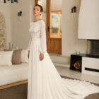 Vestido de novia Reina de Aire Barcelona 2027 con cuerpo de encaje, mangas largas de gasa, espalda ilusión y falda fluida de crepé.