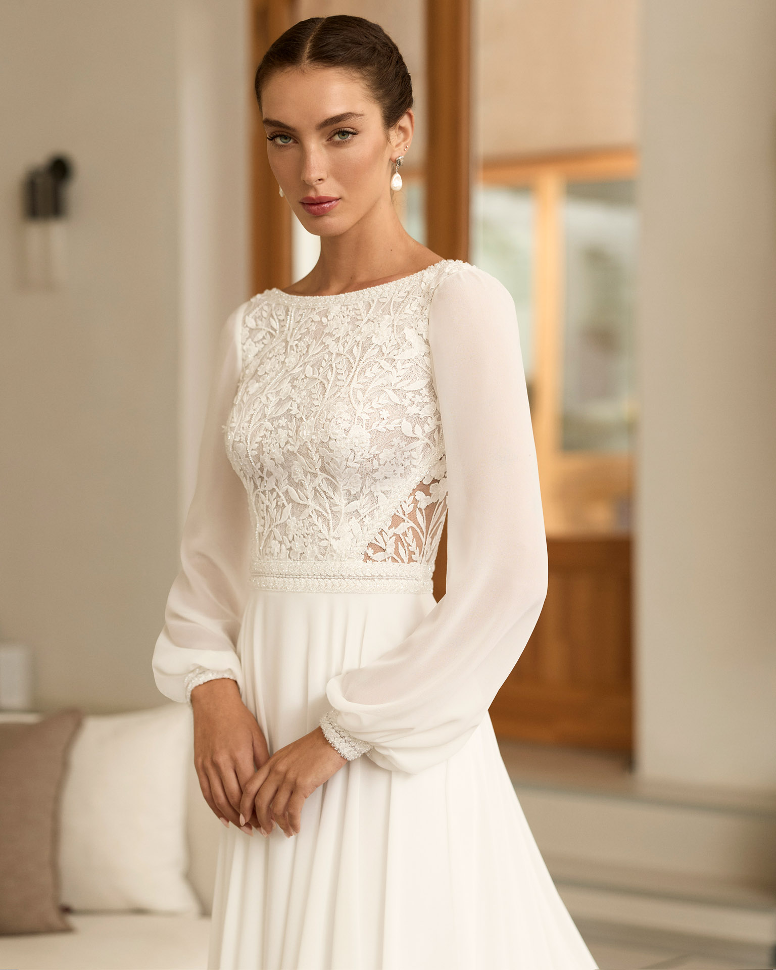 Vestido de novia Reina de Aire Barcelona 2027 con cuerpo de encaje, mangas largas de gasa, espalda ilusión y falda fluida de crepé.