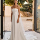 Vestido de novia Relia de Aire Barcelona 2027 con mangas largas de gasa transparente, escote barco, cintura de encaje, falda fluida de crepé y elegante espalda cerrada.